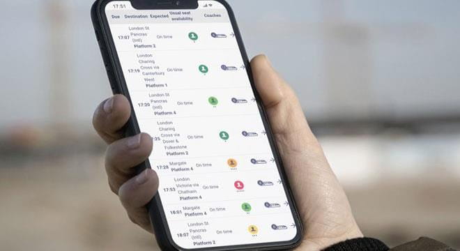 man using mobile phone to check train times