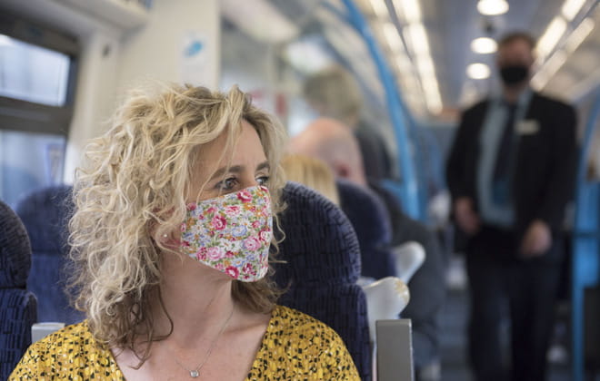 Woman on board a train wearing a face covering