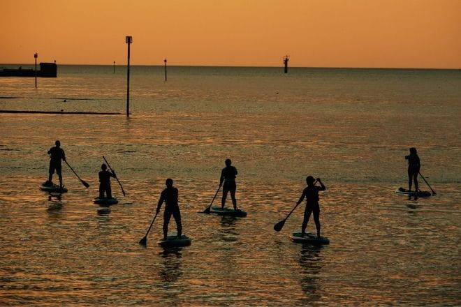 a group of people that are paddle boarding in the ocean