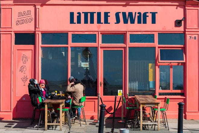 people sat in the sun outside Little Swift shop