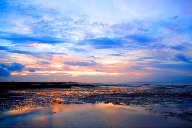 a sunset over Minnis Bay reflecting off the sea