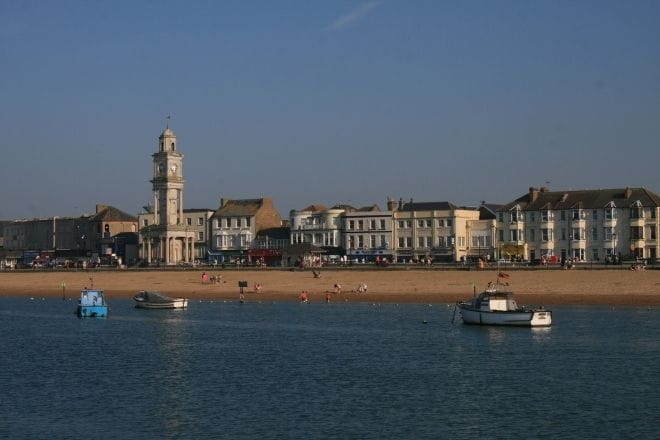 a small boat in a body of water with a city in the background