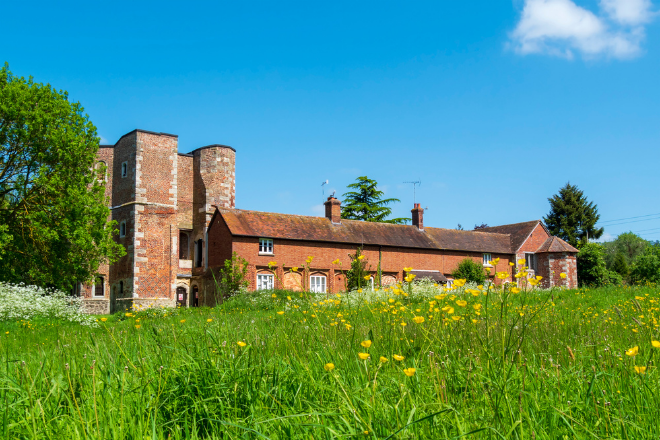 a large brick building with green grass in front of a house