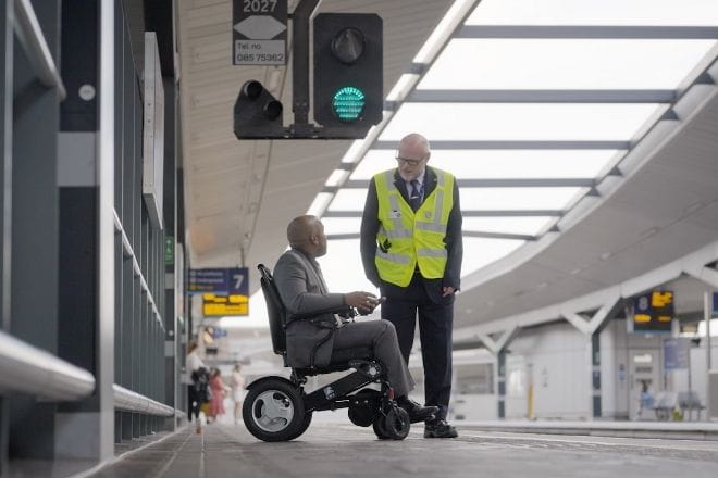 Southeastern colleague talking to a man in a wheelchair on a train platform
