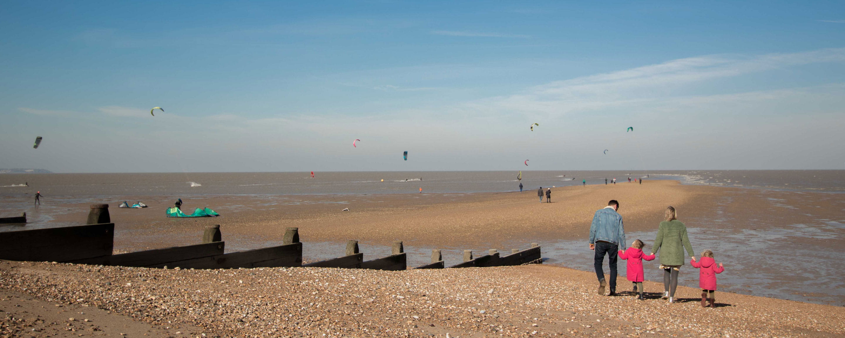 family walking along Tankerton beach