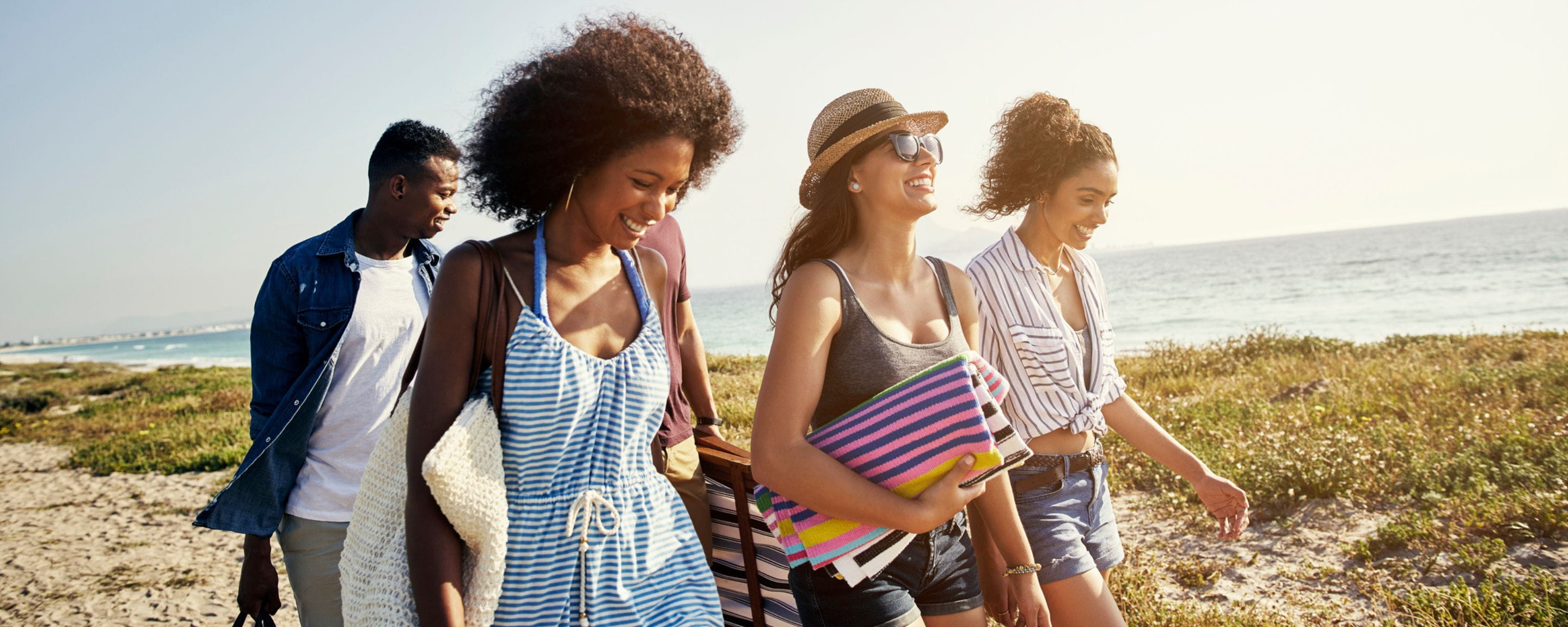 a group of friends walking down a beach