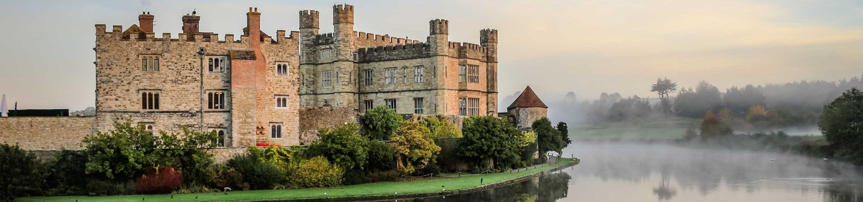 a castle with water in front of a building