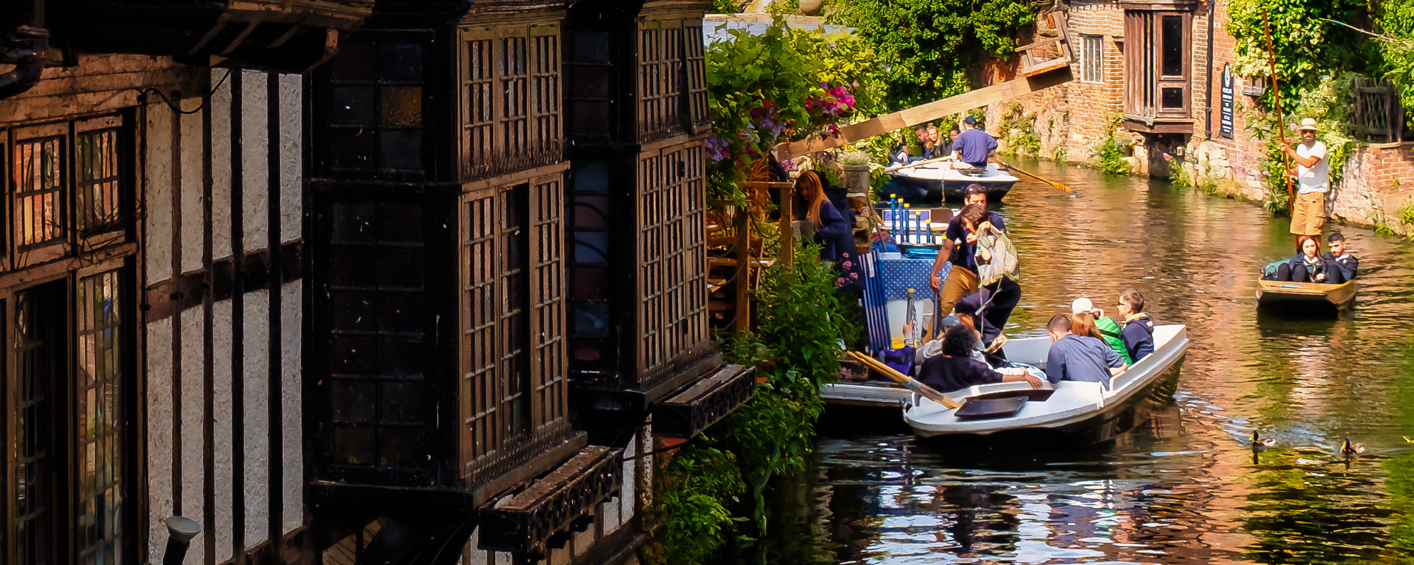 a group of friends punting down the river