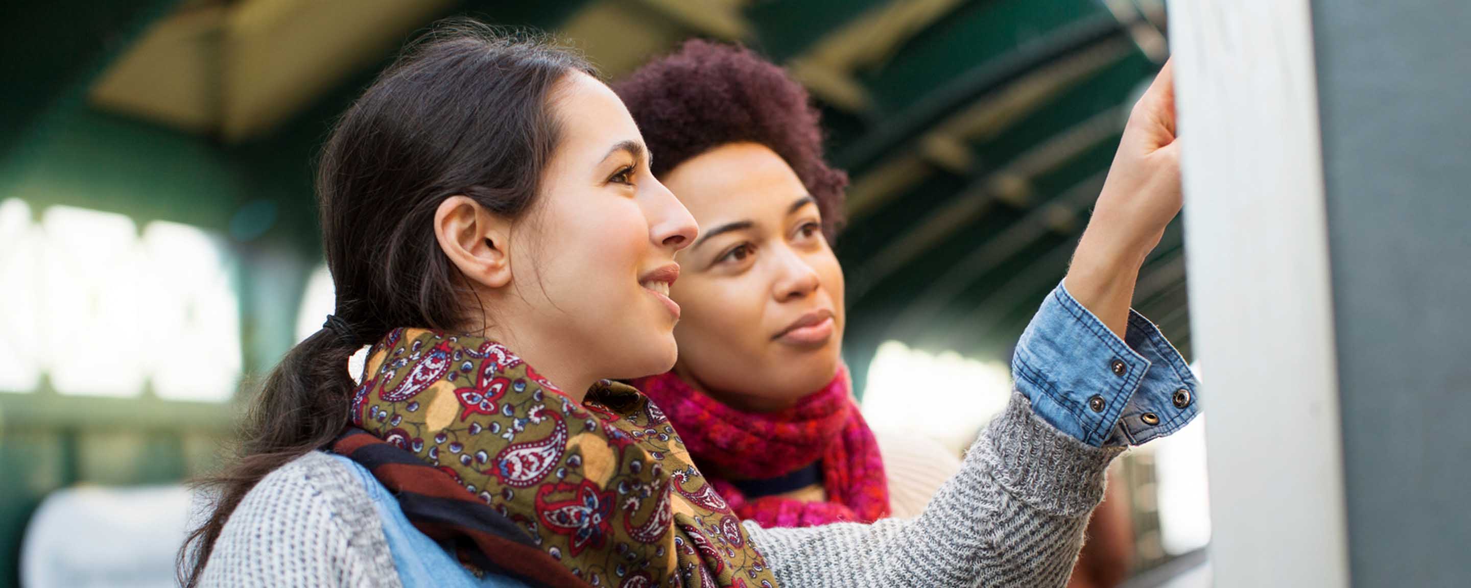 Two women checking a timetable