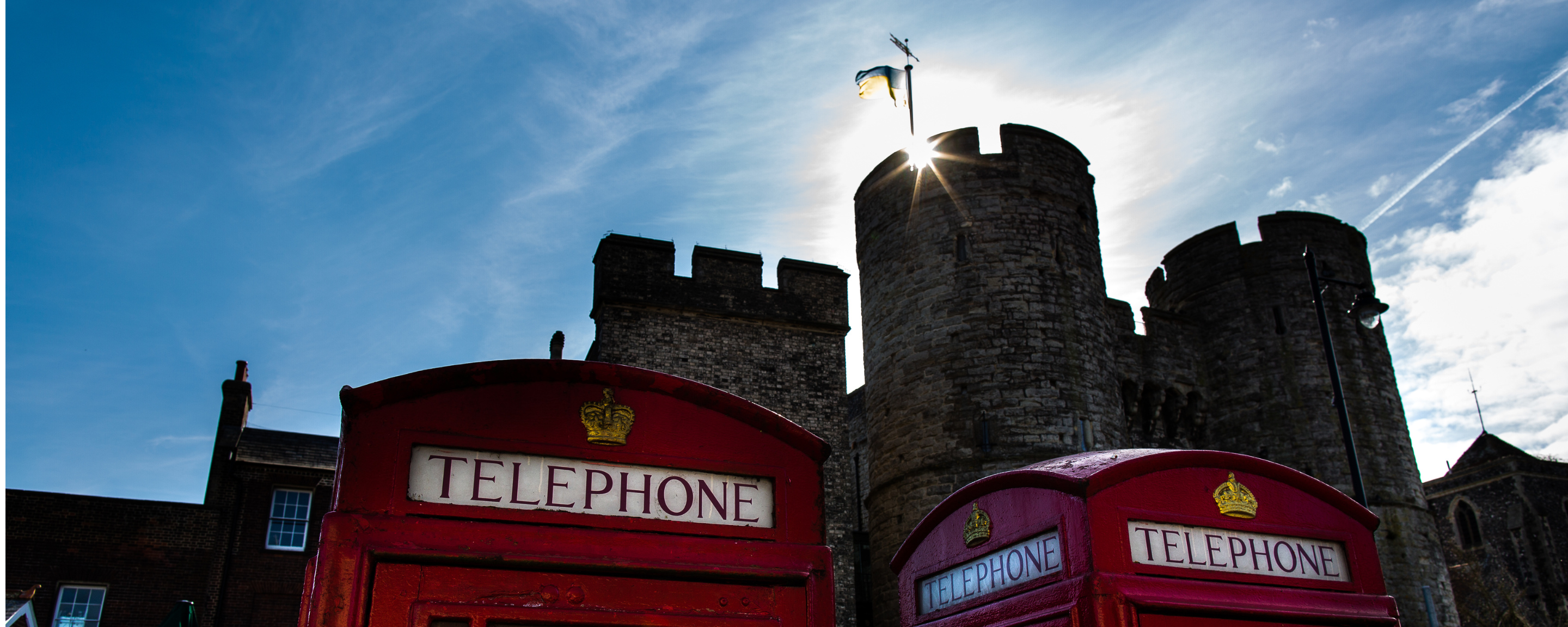 Canterbury Castle behind red telephone boxes