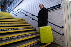 a man carrying luggage up some stairs