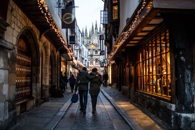 a couple walking down a cobbled street in Canterbury