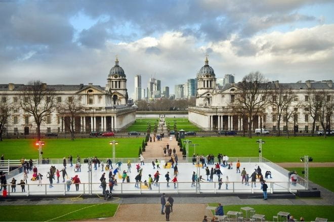 people skating on an ice rink with Queen's House in the background