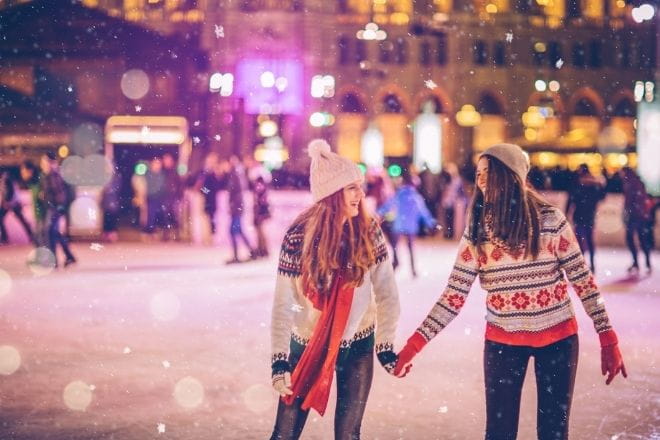 two women skating on an ice rink