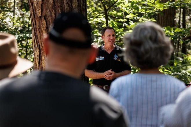 Bison Ranger giving a talk to a crowd in a fores