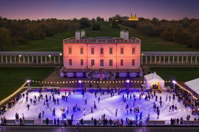 Birds eye view of Queens House lit up at night in purple