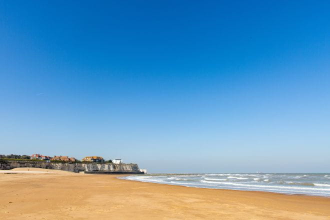 a sandy beach next to the ocean