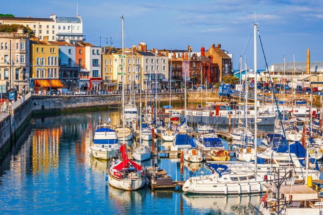 boats docked in Ramsgate harbour with building along the promenade to the left