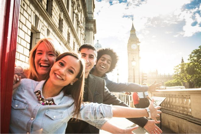 group of friends posing for a picture in London with Big Ben in the background