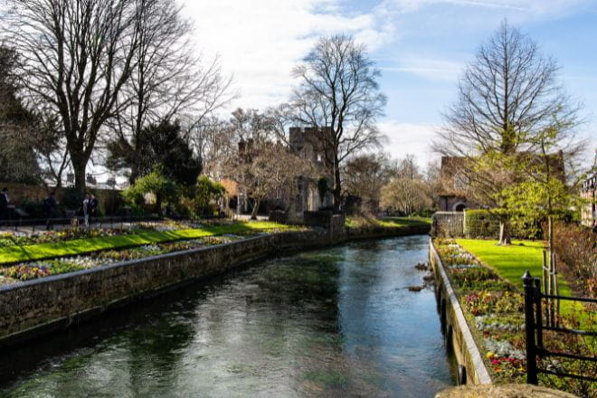 river running through Canterbury with flowers lining the river bank