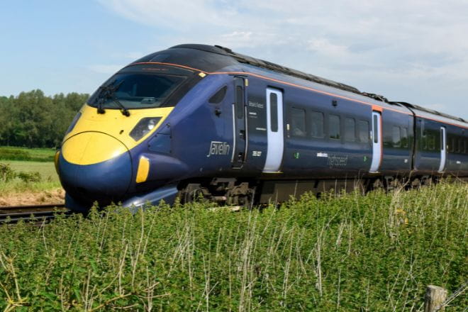 a High Speed train going down the track through a field