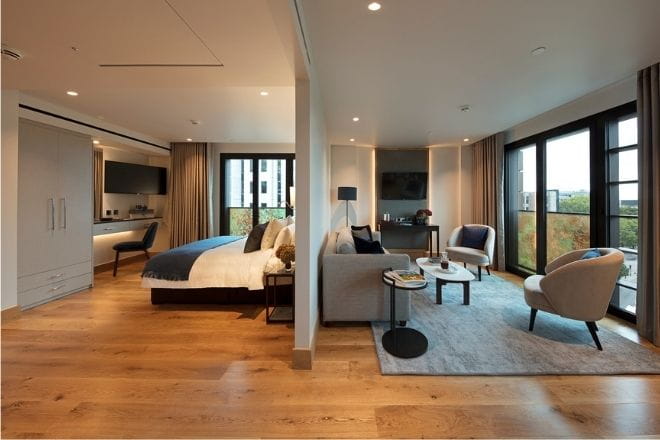 picture of a room in the Tower Suites with the bed to the left and lounge area to the right