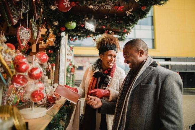 a woman and man looking at gifts at a Christmas market