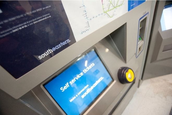 a ticket machine at a station, self service tickets is written on the screen